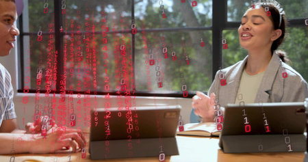 Discussing pair in work attire gesturing at wood table, grid window, tablets notes pen data overlay....