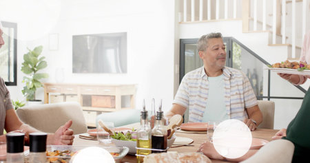 Looking man in striped short-sleeve shirt reaching for roasted platter at dining table, copy space....
