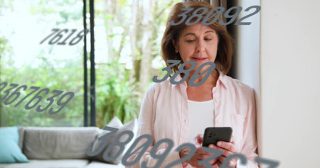 Holding smartphone, senior in pink top leaning at home by glass windows, numeric decals, copy space....