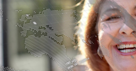 Smiling senior woman showing right face outdoors with dotted world map overlay lipstick, copy space....