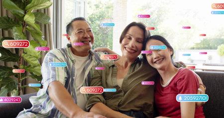 Smiling adults wearing striped olive and red shirts sitting on gray sofa. Family, together, warmth,...