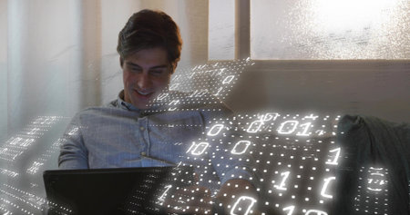 Sitting man wearing blue button-down shirt using tablet on lounge sofa, curtains, binary overlay....