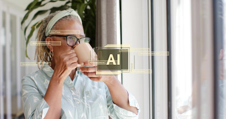 Holding and sipping mug, senior woman green-shirt glasses at home near window. Elder, eyewear,...