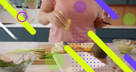 Preparing woman in pink top spreading guacamole on toast in kitchen, glass bowl avocado....