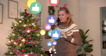 Talking woman in patterned sweater, red-white headband on phone by Xmas tree with thumbsup icons....