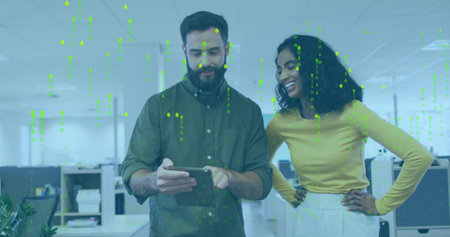 Holding tablet olive-shirt man and yellow-top woman leaning, viewing in open office, binary overlay....