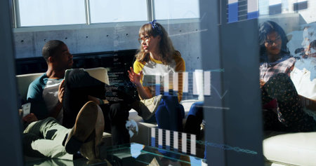 Talking four casual team gesturing and working in office lounge, with glass partition and phones....