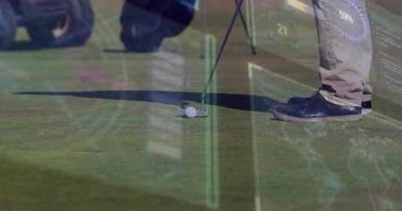 Putting golfer's lower legs aligning putter on putting green, showing golf ball, tan trousers....