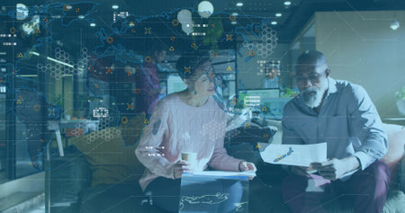 Reviewing woman in pink sweater, man studying printed charts with coffee cup, AR overlay, office....