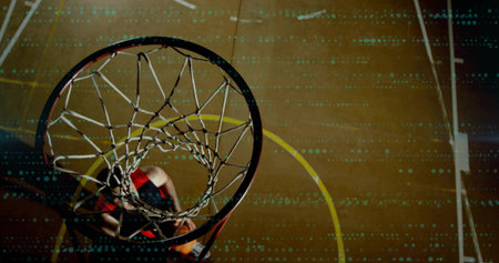 Driving player wearing red jersey jumping under rim with braided net at gym orange ball showing....