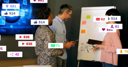 Discussing team pointing at flipchart in meeting room, with pink top, showing social badges display....