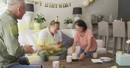 Celebrating man in striped shirt and gold party hat leaning toward cake in living room. Birthday,...
