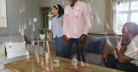 Standing man in pink shirt addressing group in living room, wooden coffee table and binary overlay....