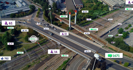 Spanning elevated highway overpass carrying cars over multi-track railway, showing data overlays....