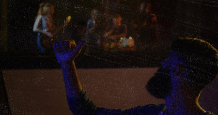 Right bearded man raising thumb toward screen in club, shirt, with guitar, drums, ledge, copy space....