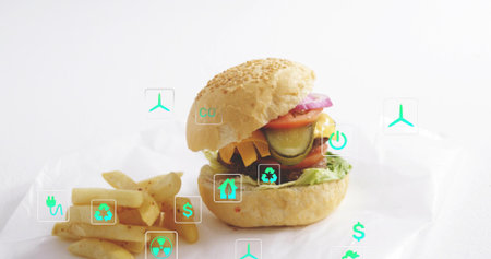 Showcasing sesame bun cheeseburger sitting on crumpled paper at studio, with fries and eco icons....