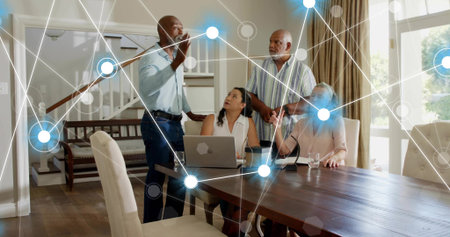 Discussing four family members leaning around dining table in home, with laptop network graphic....