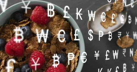 Showing blue bowl of bran cereal sitting left on slate table, with berries, spoon, currency symbols....