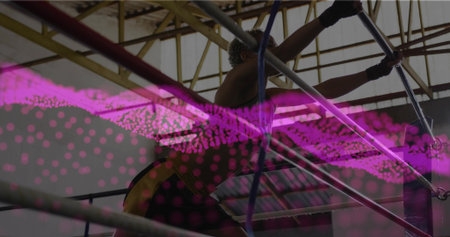 Pulling gymnast in sleeveless top, shorts on uneven bars at gym with wrist grips, magenta overlay....