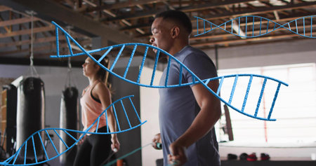 Skipping man wearing athletic shirt jumping rope at gym with punching bags, DNA overlay, copy space....