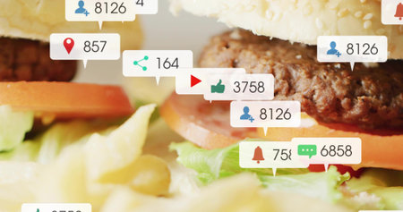 Showing stacked burger with sesame bun, beef patty at tabletop, tomato lettuce fries callouts....