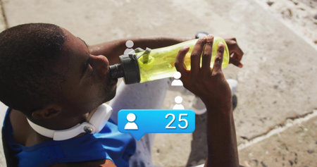 Drinking man wearing blue tank top holding neon green bottle, headset on concrete steps, overlay 25....