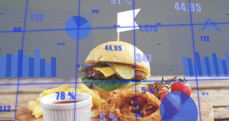 Displaying hamburger with fries and onion rings resting on wooden board, with blue data overlays....