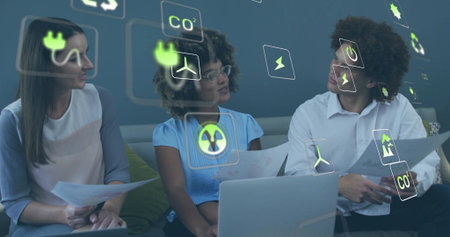 Discussing team wearing business attire reviewing papers in lounge, with laptop and energy icons....