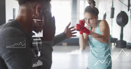 Holding focus pads, coach guiding athlete in teal top punching in gym, red wraps, data overlays....