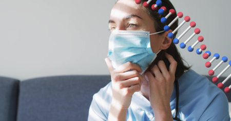 Adjusting scrub-clad nurse touching surgical mask and neck on couch with light bands, steth and DNA....