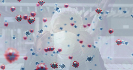 Adjusting mask, man in light cap and dark jacket raising hand at station, with virus overlay....