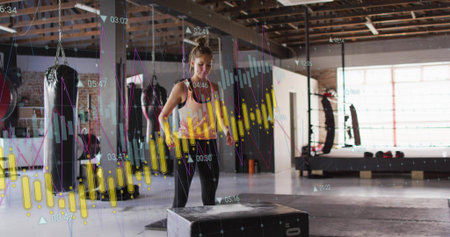Preparing woman bracing for plyo box jump in industrial gym, wearing tank and leggings with data....