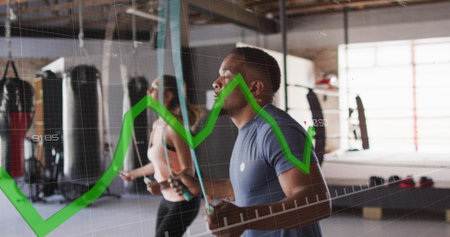 Skipping man in fitted blue athletic shirt jumping rope at boxing gym, showing green graph overlay....