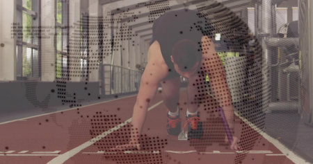 Preparing sprinter in black top and orange shoes on track, starting blocks and dotted map overlay....