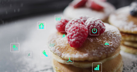 Showing small stack of pancakes topped with raspberries on dusted table, with floating eco icons....