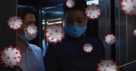 Standing female wearing bright blue mask, dark top holding device in elevator, with virus graphics....