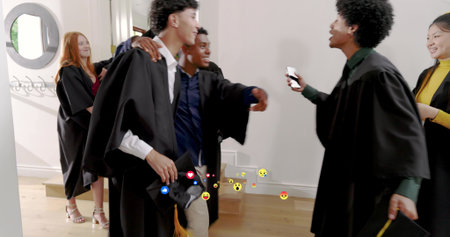 Greeting graduating students in black gowns, sharing mortarboards and smartphone reactions in foyer....