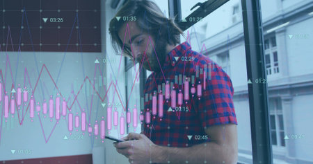 Holding smartphone, man in red-blue plaid shirt checking trades by office window, overlaid charts....