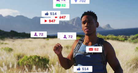Standing adult man in blue tank top with backpack in coastal meadow, showing floating notifications....