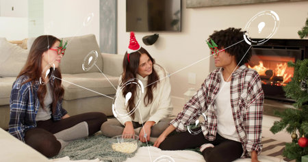 Passing clear bowl popcorn women sitting on living room rug, wearing holiday glasses and Santa band....