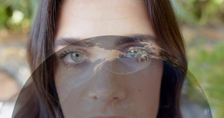 Focusing adult woman occupying central frame in garden, showing translucent circular globe overlay....