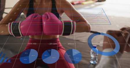 Sitting female wearing black top red leggings holding pink gloves in gym showing metric charts....