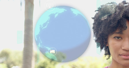 Showing adult woman wearing pink top facing right outside, viewing clear globe UI icons, copy space....