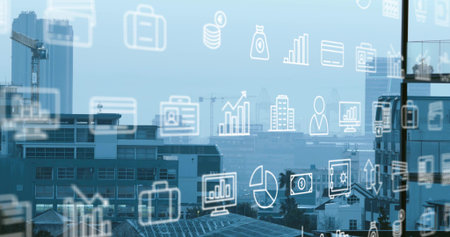 Displaying foreground business icons overlaying glass pane at office, with cranes and rooftops....