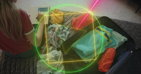 Packing traveler in red T-shirt and shorts marking checklist on bed with open suitcase, copy space....