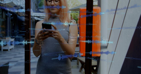 Checking phone, pink-haired woman in grey dress with glasses standing near cafe glass, blue overlay....
