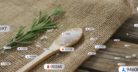Resting wooden spoon with coarse sea salt sitting on burlap with rosemary and notification badges....