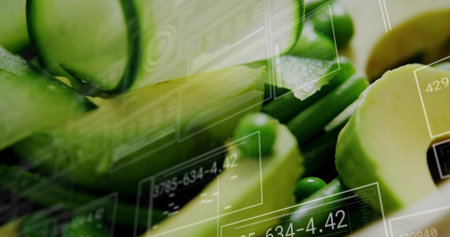 Showing halved avocados cucumber slices peas and green stalks on dark board, with digital overlays....