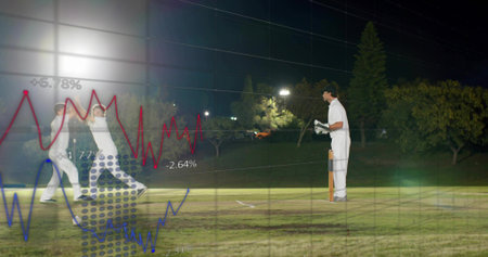 Standing batsman holding bat wearing pads at crease under lights, with chart overlays, copy space....
