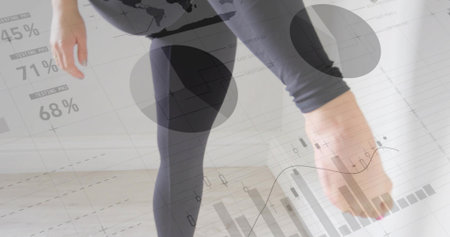Stretching woman, reaching foot at studio, wearing dark capri leggings, data overlays 45% 71% 68%....